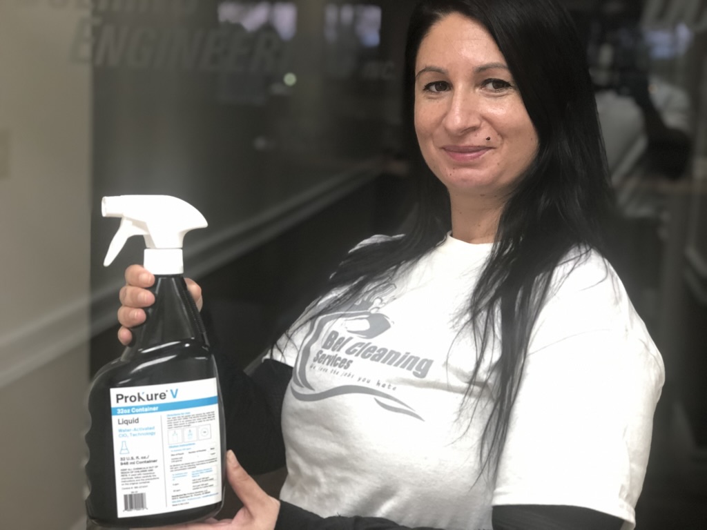 Bel Cleaning team member with ProKure V professional disinfectant for commercial sanitizing
