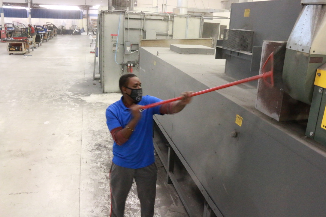 Bel Cleaning technician using an extended reach pole to clean industrial ducts