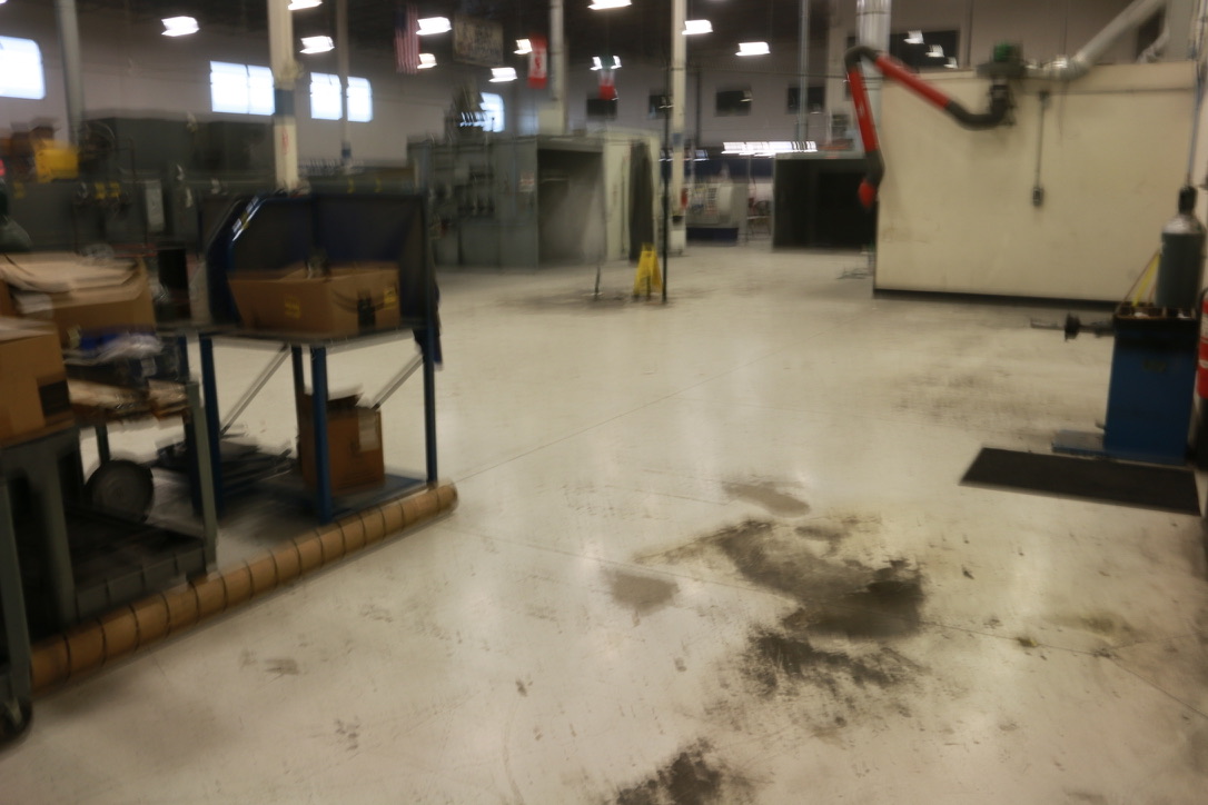 Heavily soiled industrial manufacturing floor before Bel Cleaning service