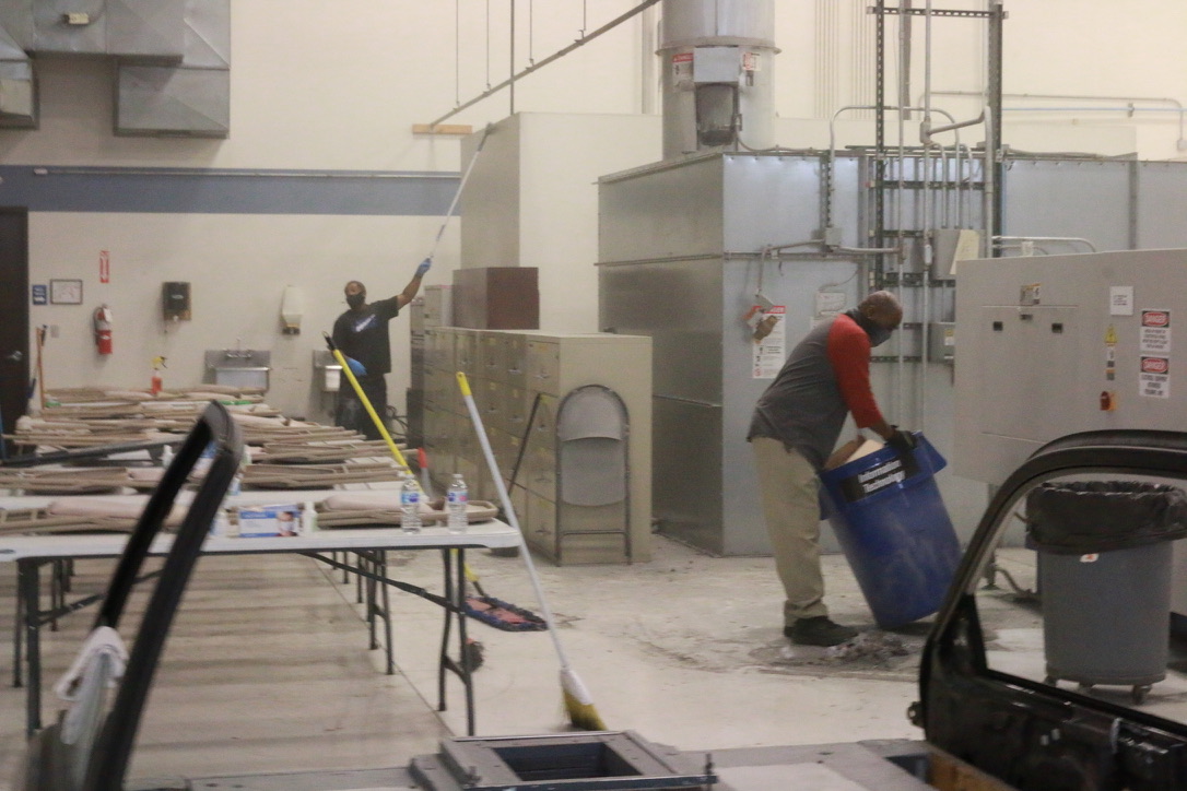 Bel Cleaning team members cleaning walls and removing debris at an industrial site