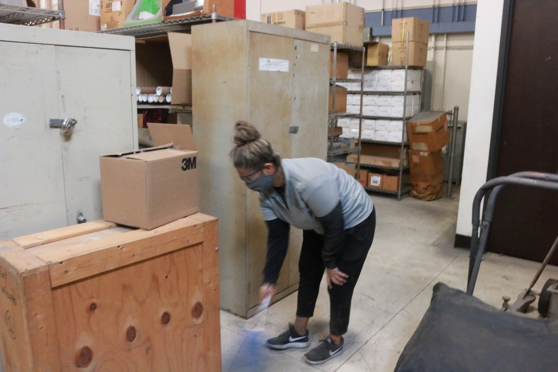 Bel Cleaning crew member performing detail cleaning in a warehouse storage area